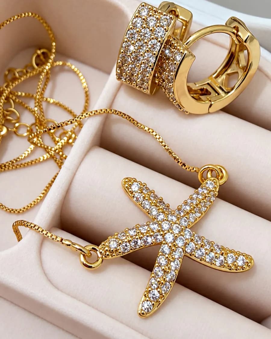 Colar de estrela-do-mar e argolas cravejadas de zircônia num porta-joias